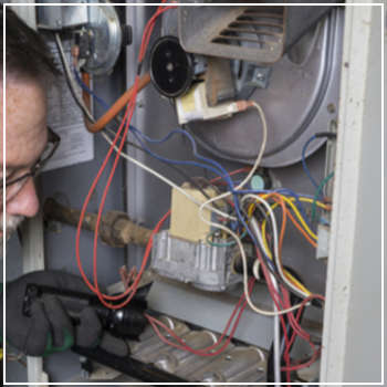 technician inspecting a furnace