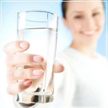 woman holding out a glass of water