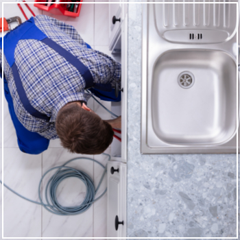 plumber fixing sink clog