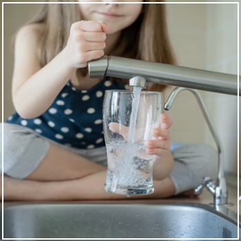 girl filling glass of water