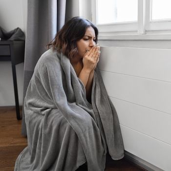 shivering woman wrapped in blanket