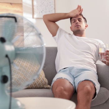 man on a hot day with fan and water